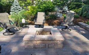 a firepit built into the landscaping in the backyard of a home